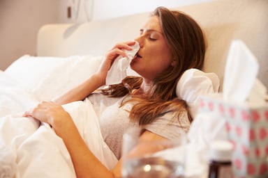 woman in bed blowing nose_GettyImages-485932628