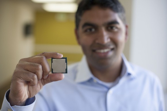 Intel executive Anand Srivatsa holding an eighth-generation Core processor, with the processor in focus
