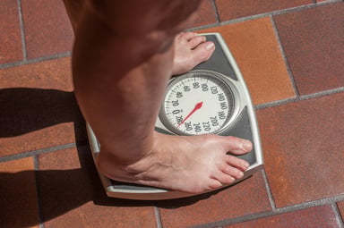 man standing on scale_GettyImages-830840462