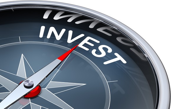 A compass pointing towards the word "invest"