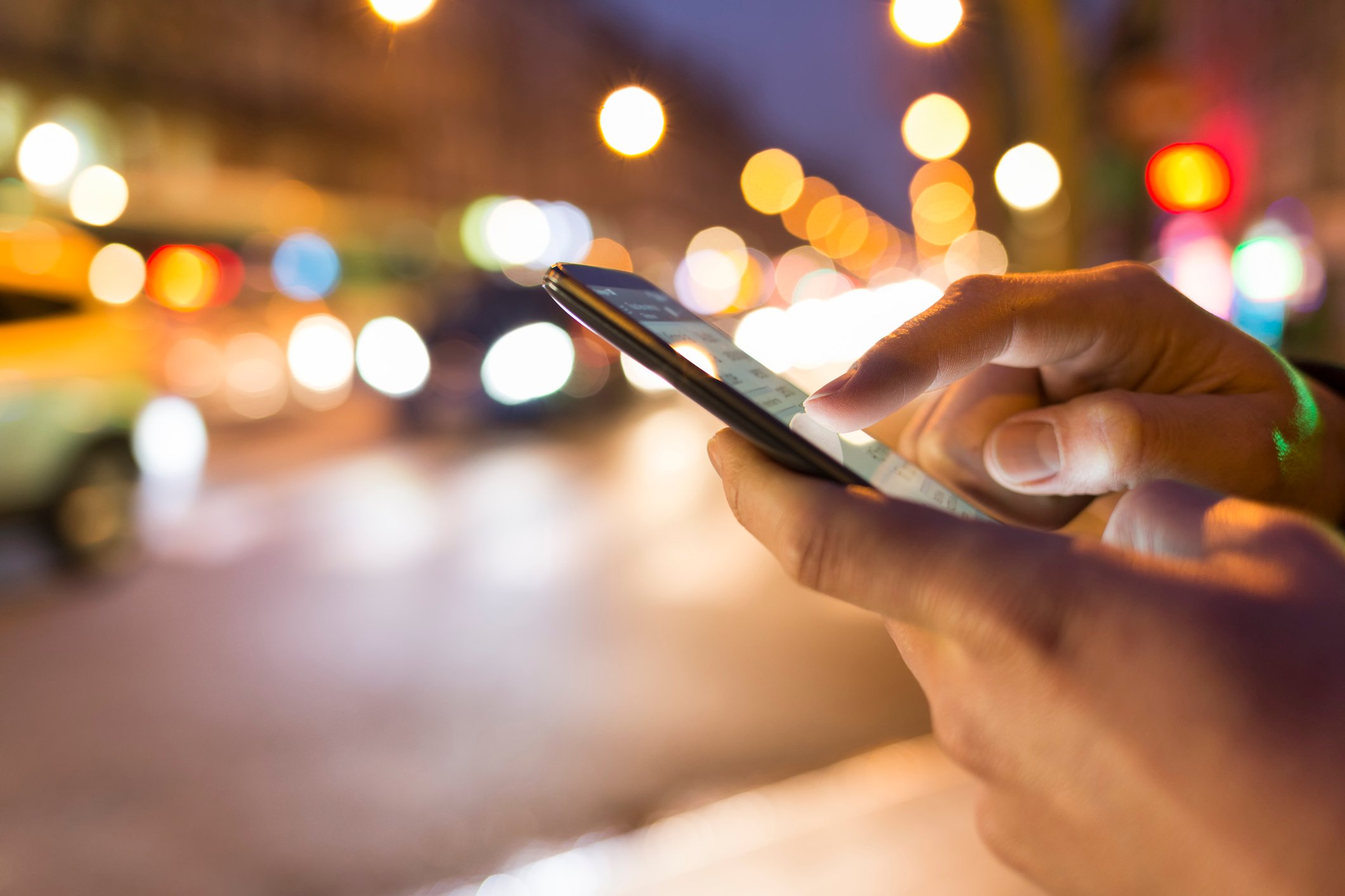 hands holding and using a smartphone at night