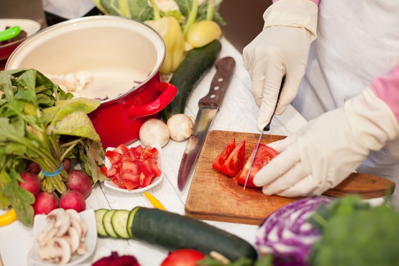 A woman cuts fresh produce.