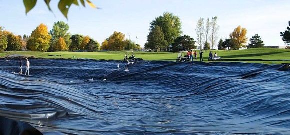 An empty golf course pond with black lining installed.