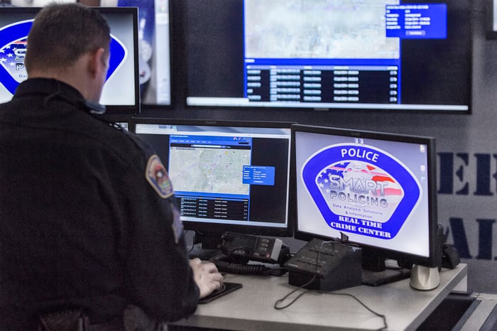 Police officer working with Axon products on a computer. 