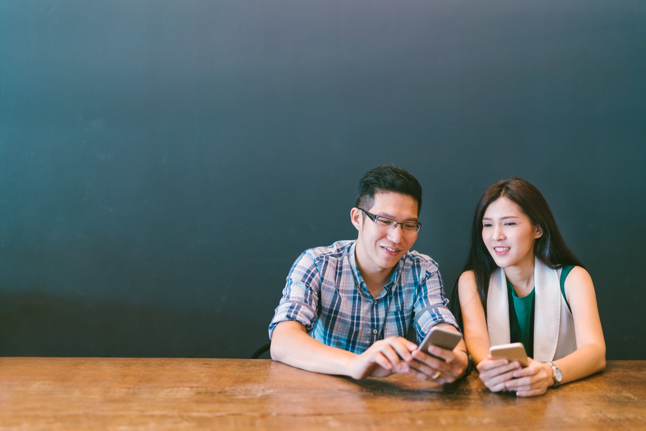 A young couple using smartphones.