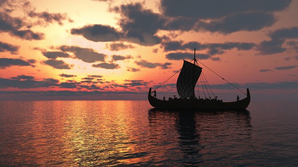 Viking longship sailing on a calm sea at sunset.