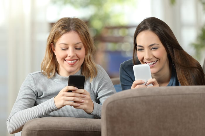 Two women looking at their phones.