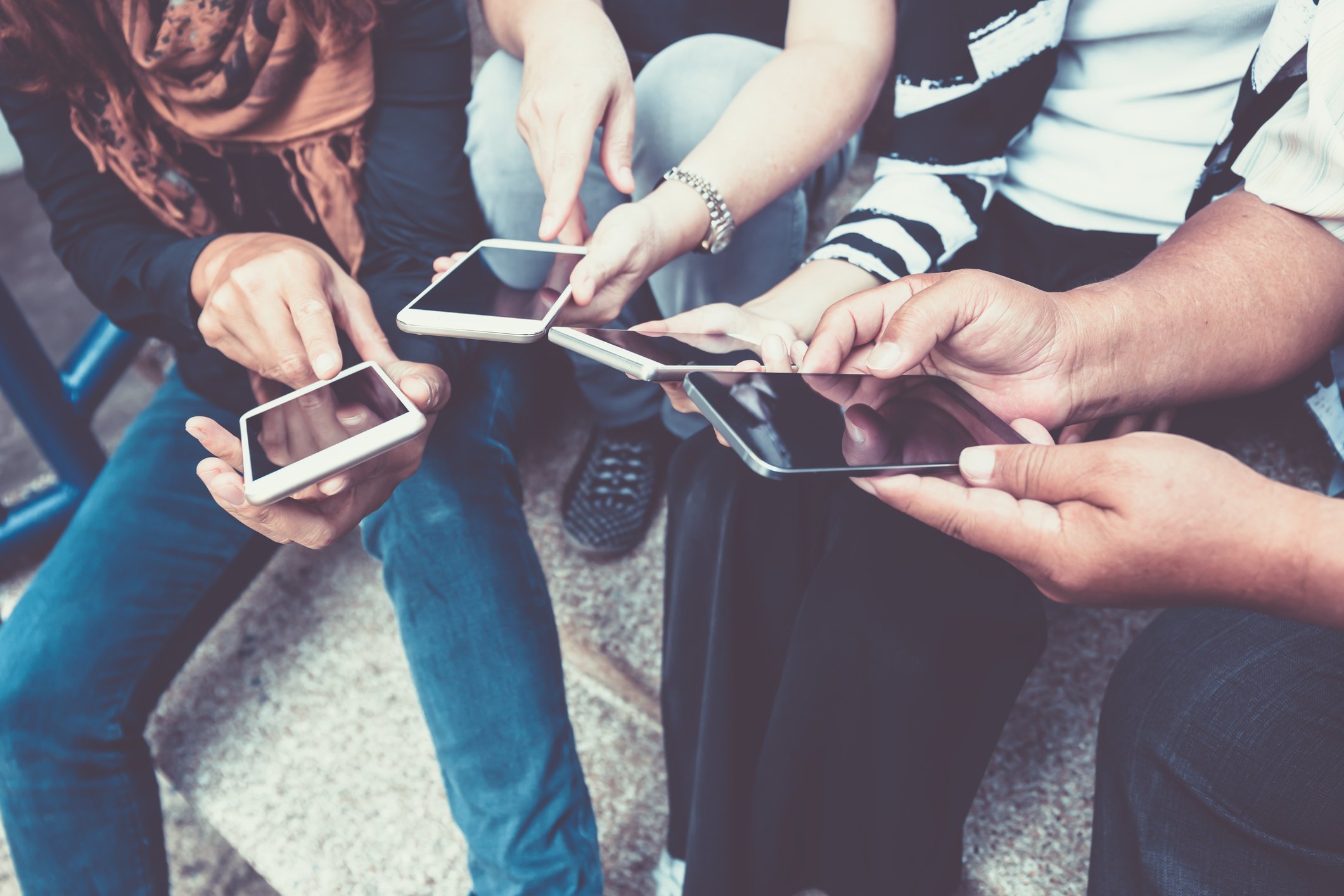 People sitting down and looking at their phones.
