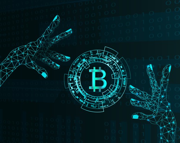 Pair of electronic hands and bitcoin symbol