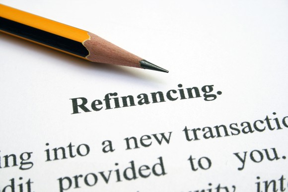 A piece of paper on which is printed Refinancing, with a pencil next to it