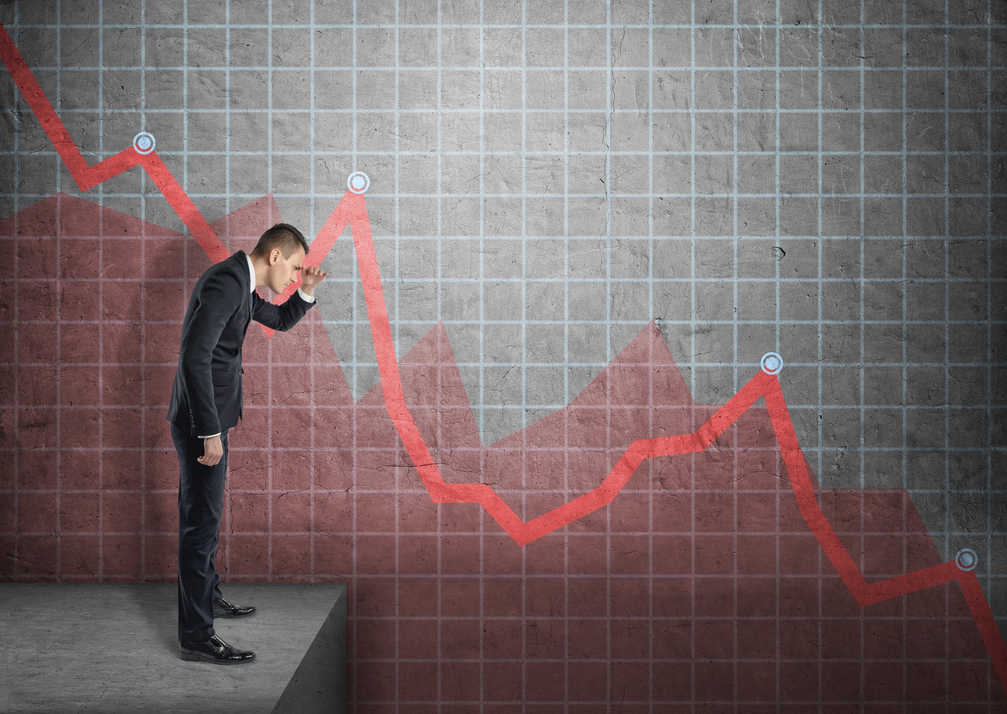 Businessman looking at falling line chart