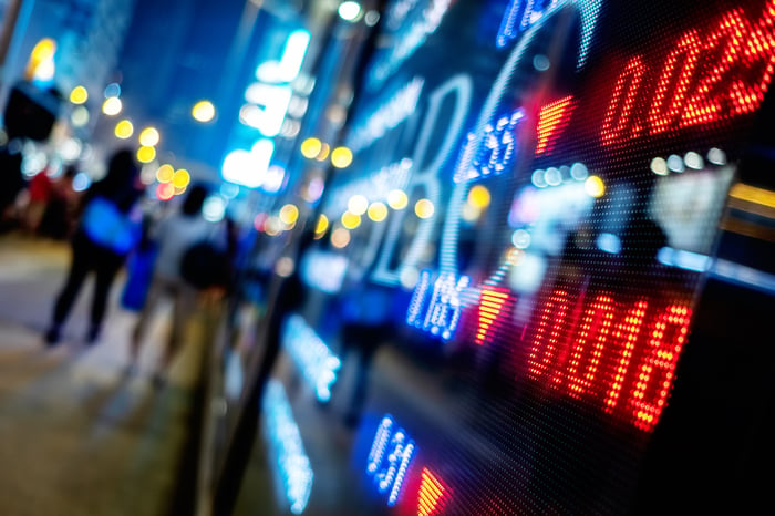 City street at night with stock price display.