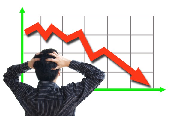 A man looking confusedly at a falling stock chart.