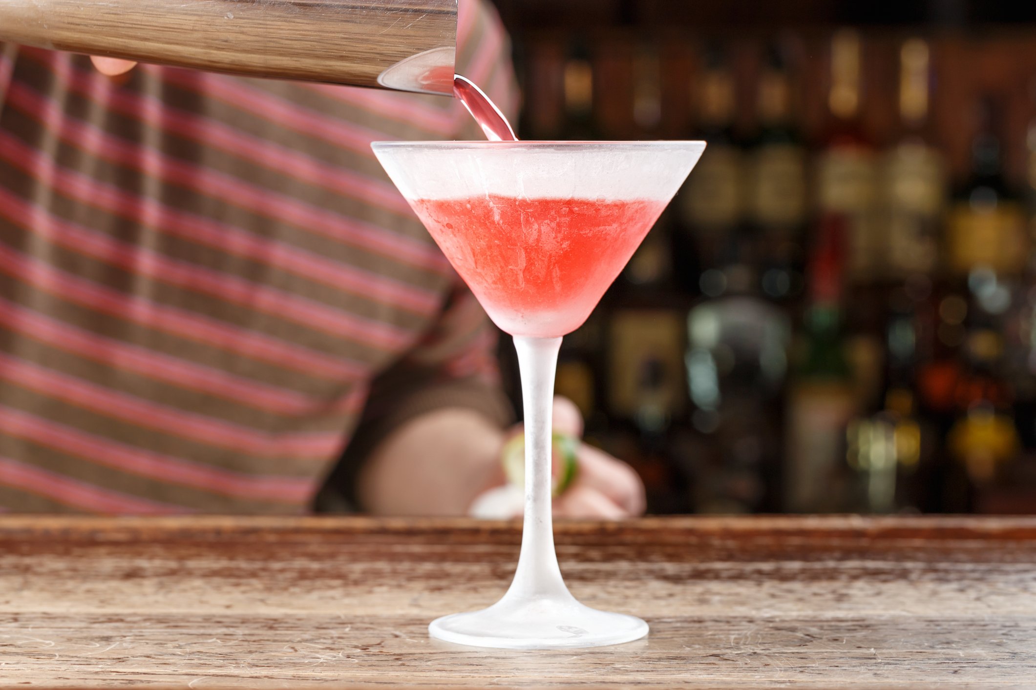 A person pours a cocktail.