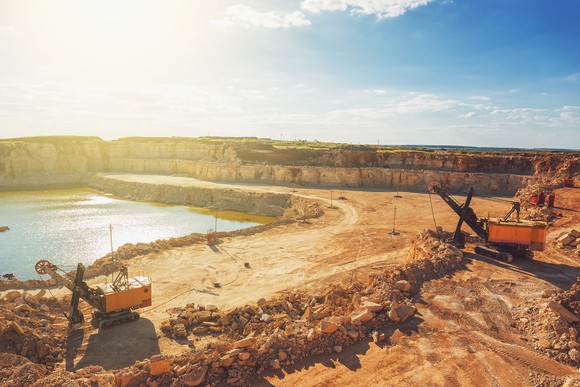 Large machinery working at a copper mine with the sun shining over head.