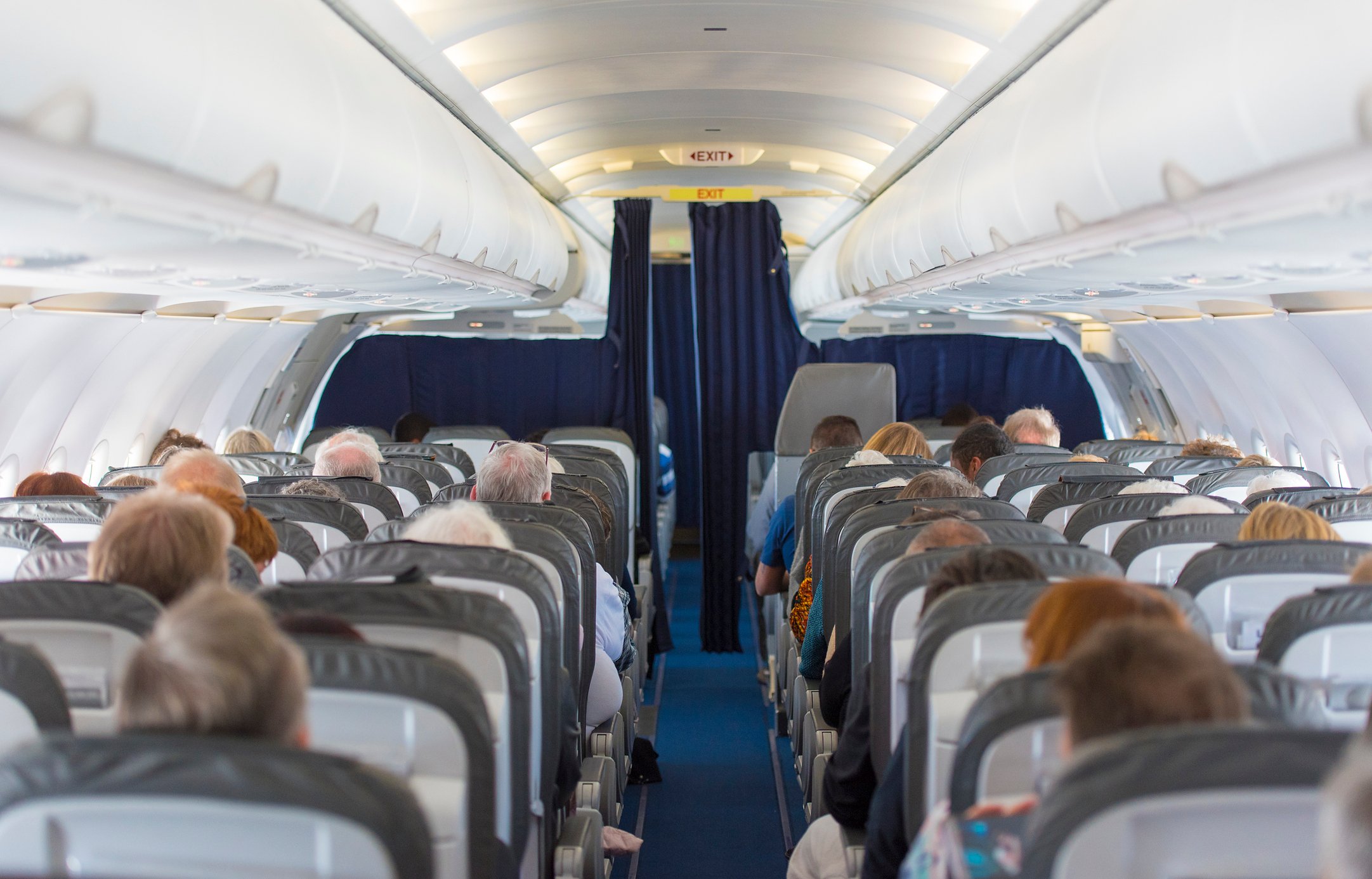 People are seated on a plane. 