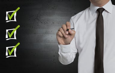 Man holding pen with 3 checkboxes
