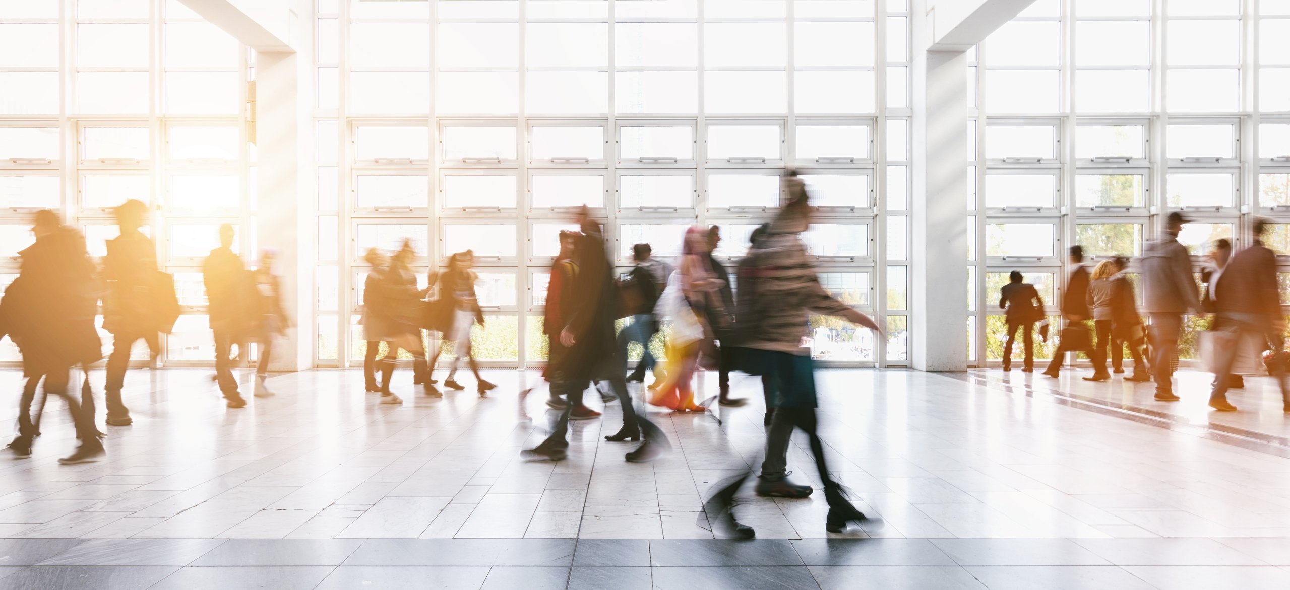 A blurred image of people walking through an airport.