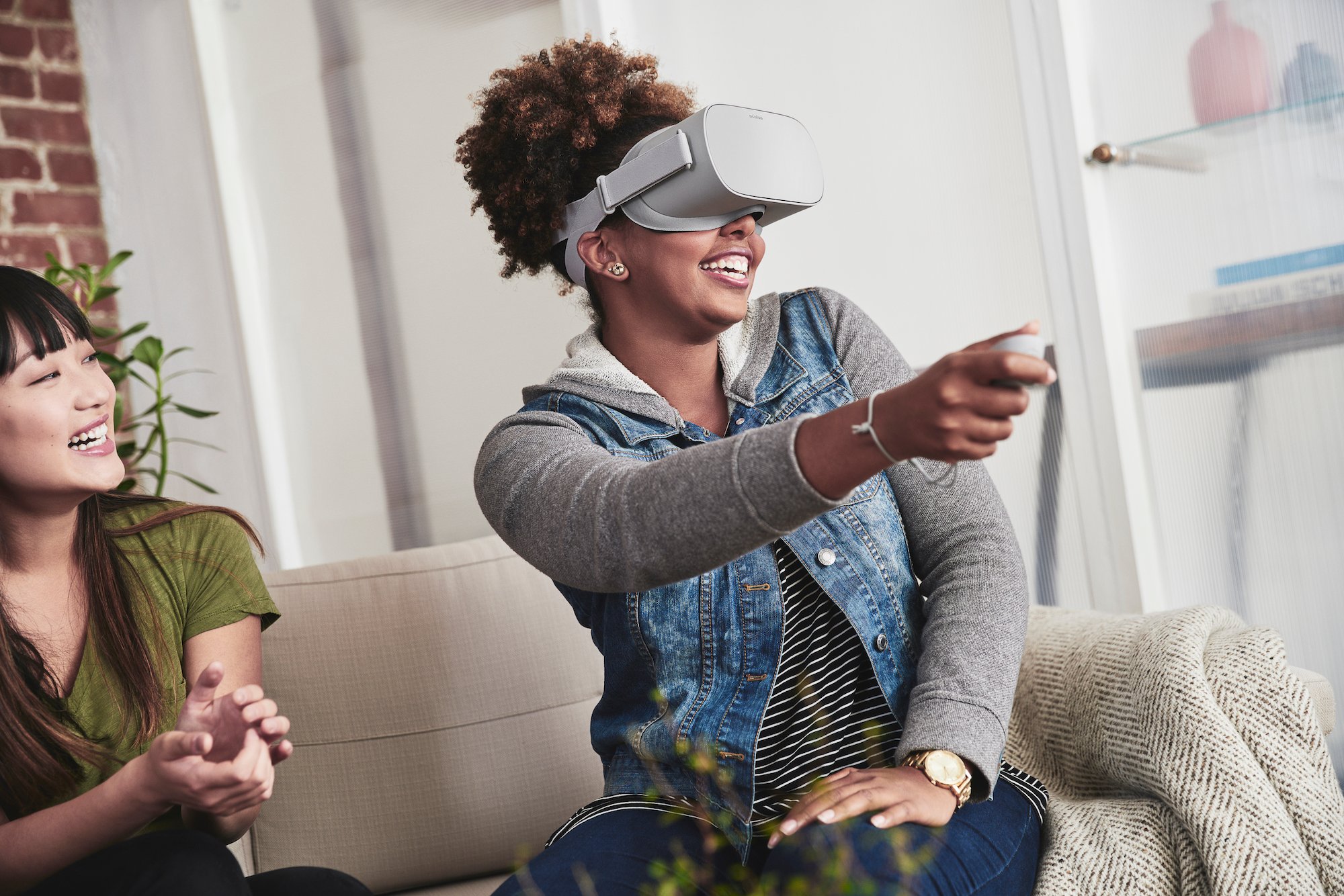 Woman sitting on a couch while using Oculus Go