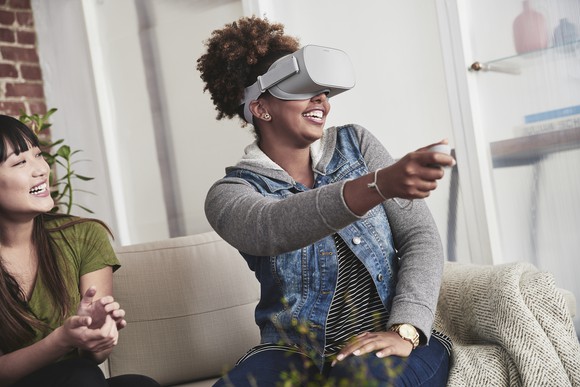 Woman sitting on a couch while using Oculus Go