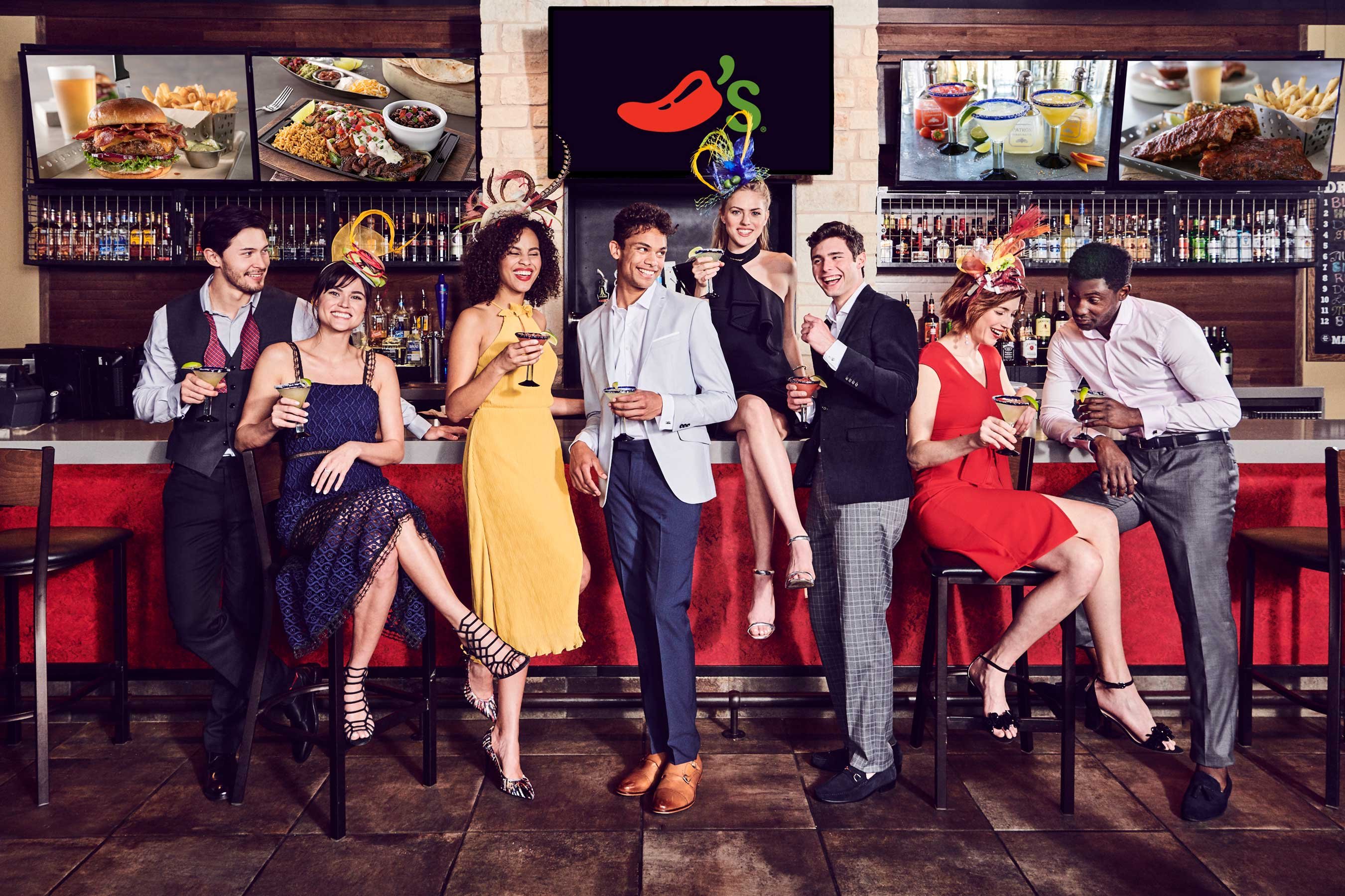 Group of men and women standing at a bar at a Chili's restaurant.