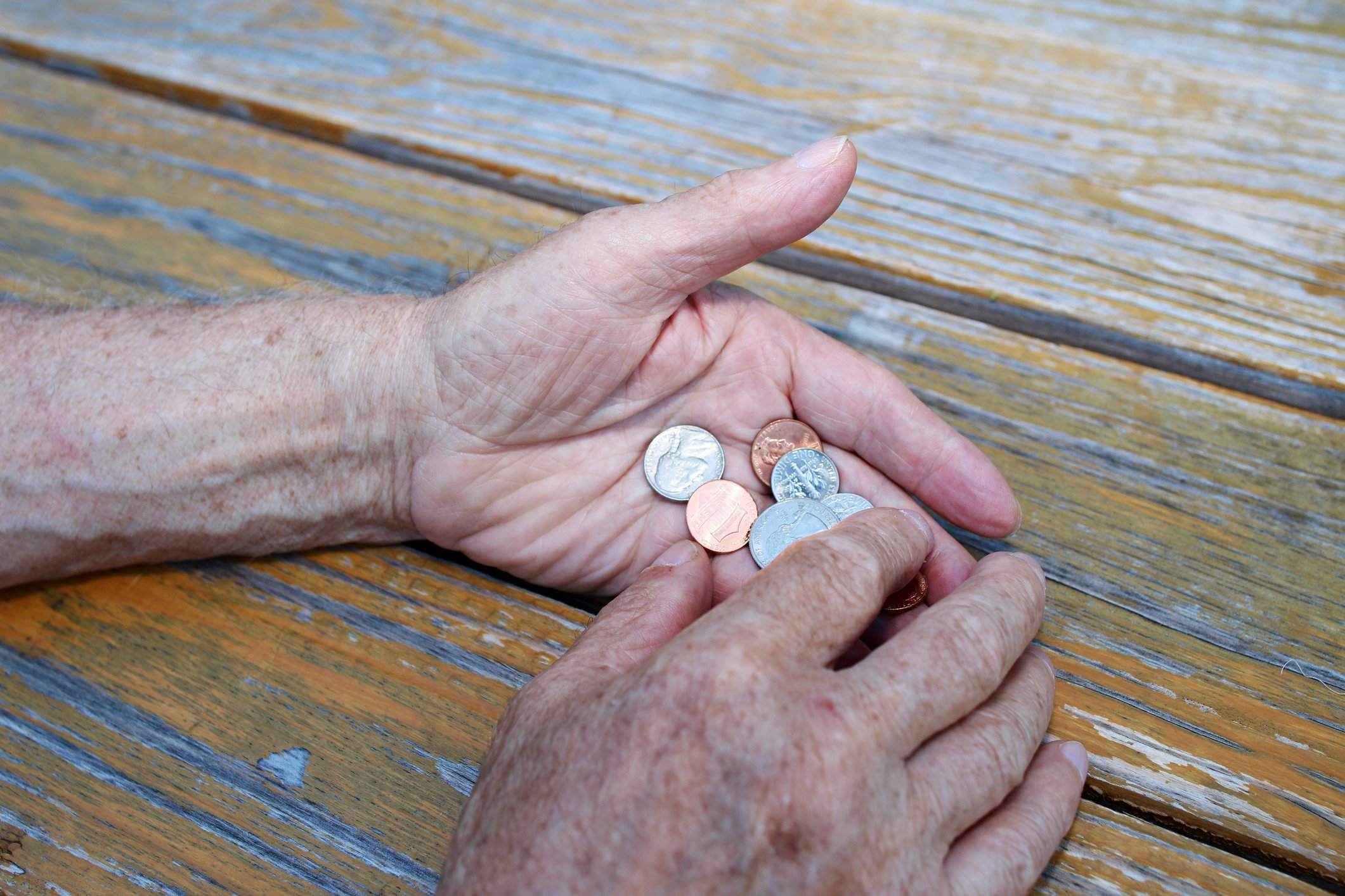 Senior holding a bunch of coins