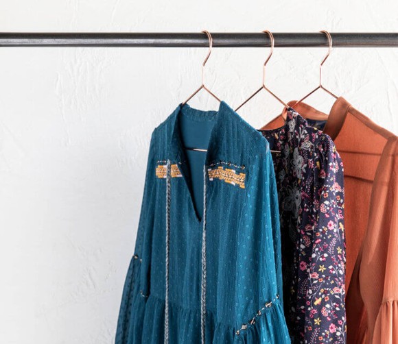 Three blouses hanging on a rack.