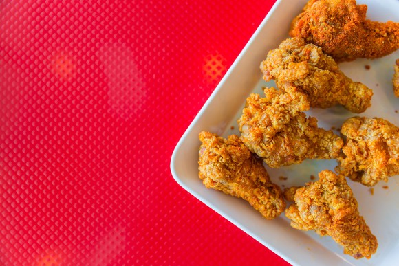 Fried chicken on a plate with a red background.