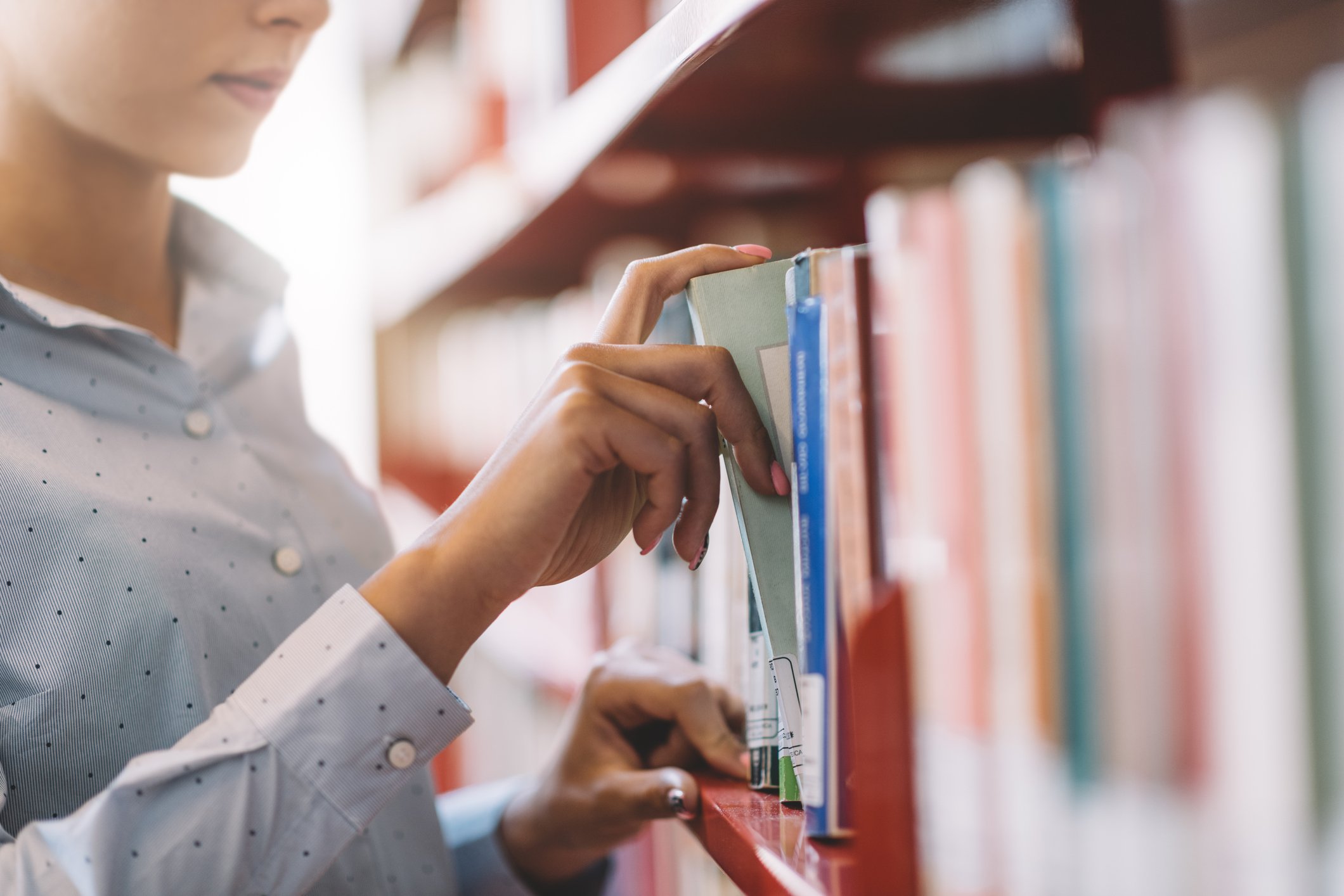 A person browses a shelf full of books.