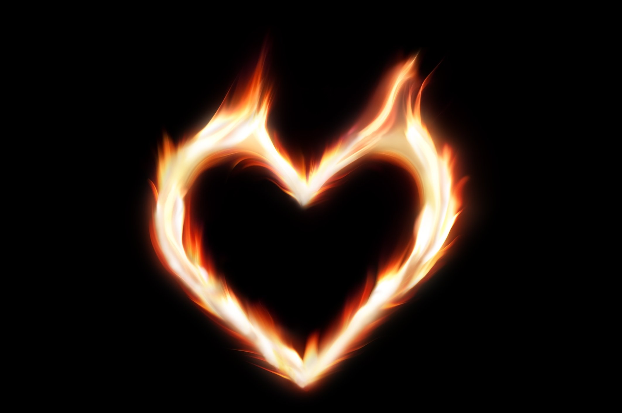 The shape of a heart in flames, against a black background