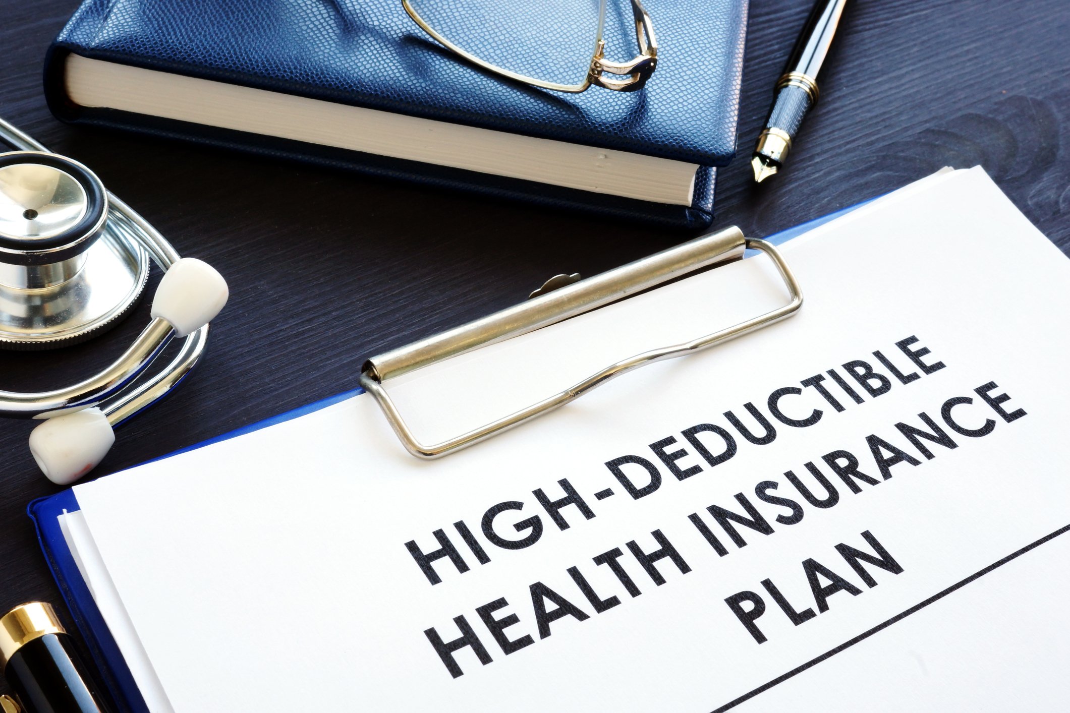 Words high deductible health insurance plan written on clipboard