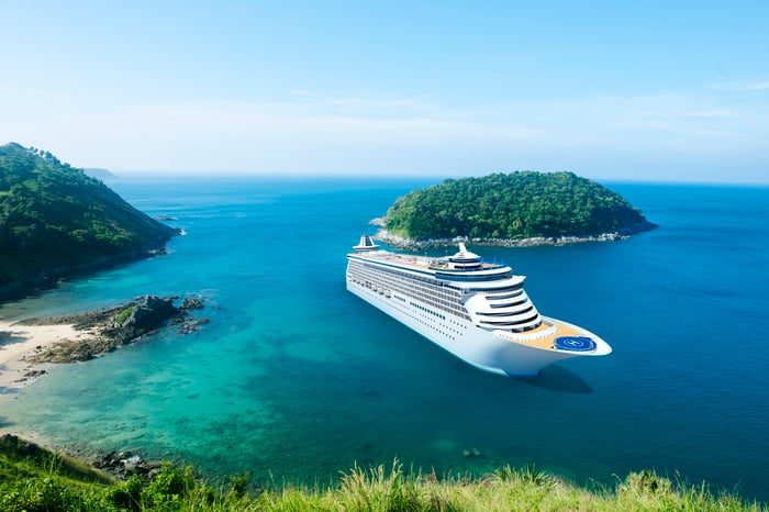 A docked cruise ship in a small tropical harbor.