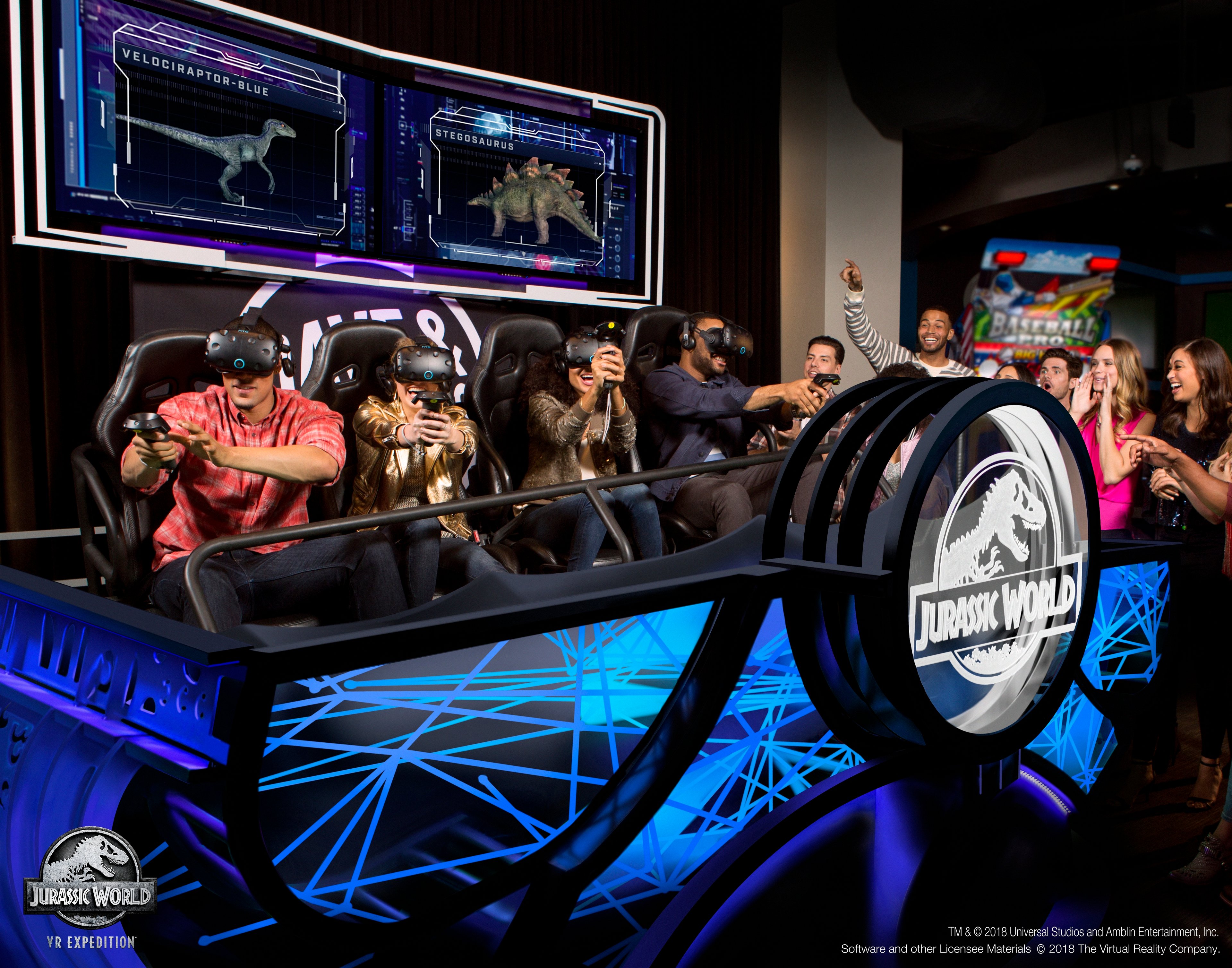 Four people playing Jurassic World VR Expedition. Onlookers cheer the gamers on.