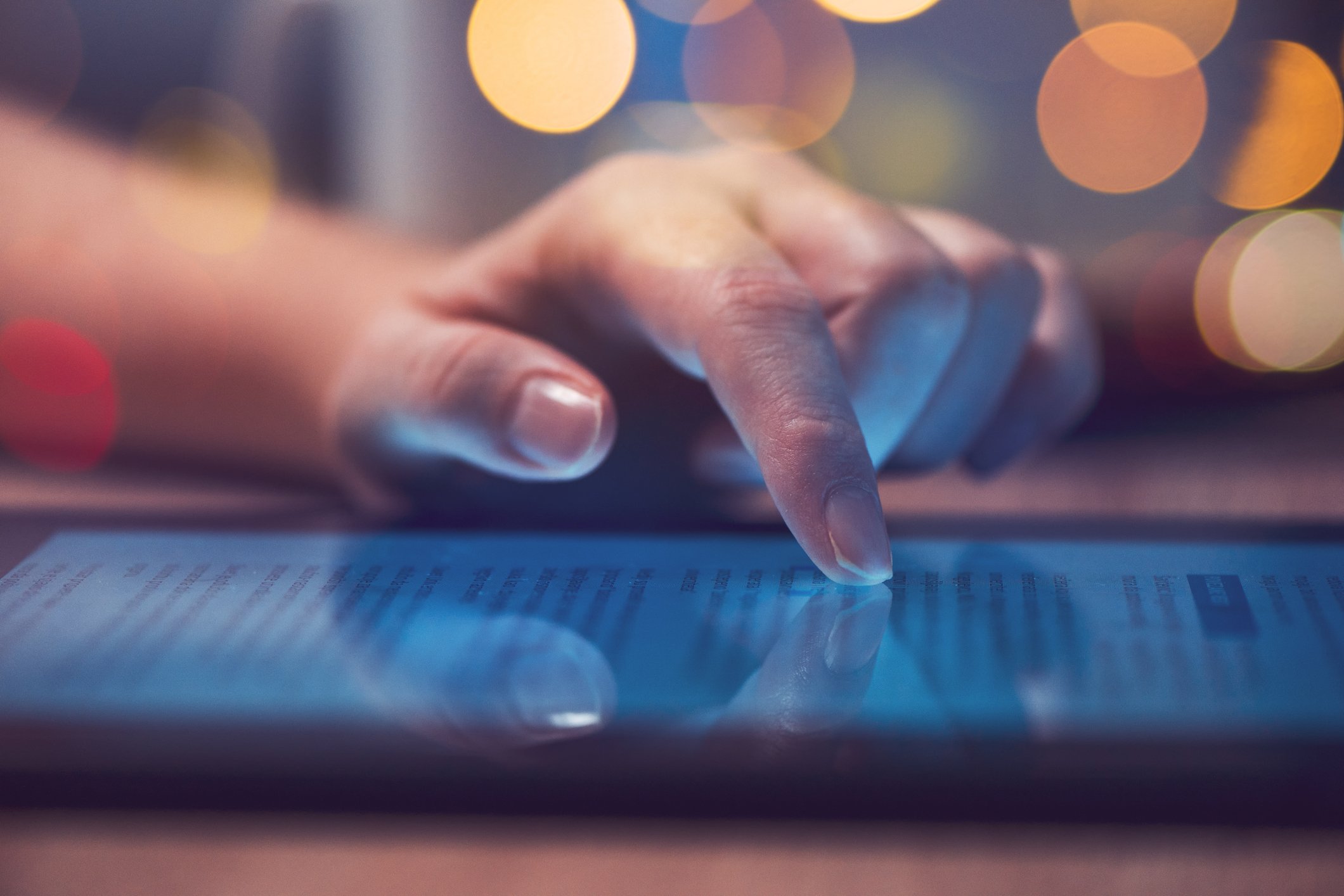 A woman reads a story on a tablet.