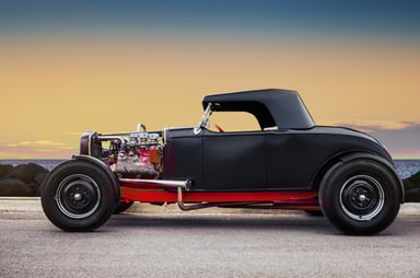 black custom hot rod car on a coastal road