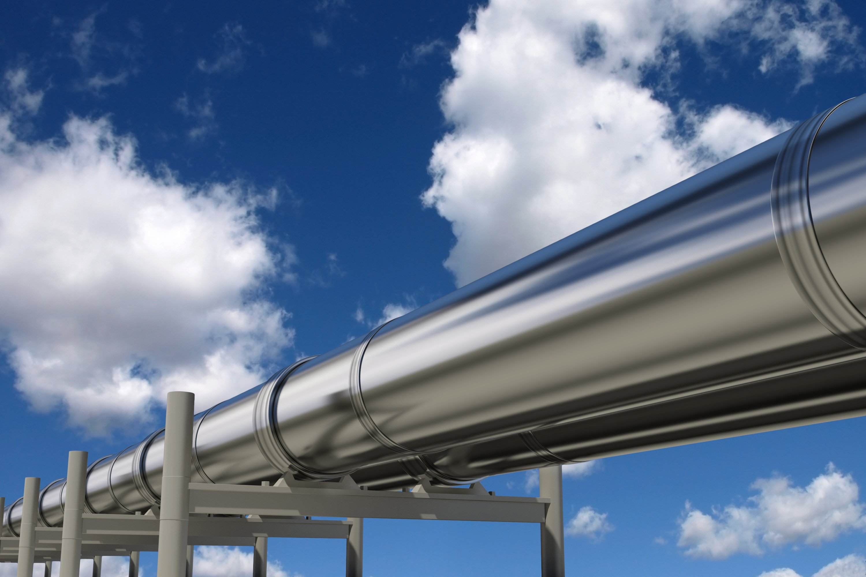 Silver pipelines under a blue sky.