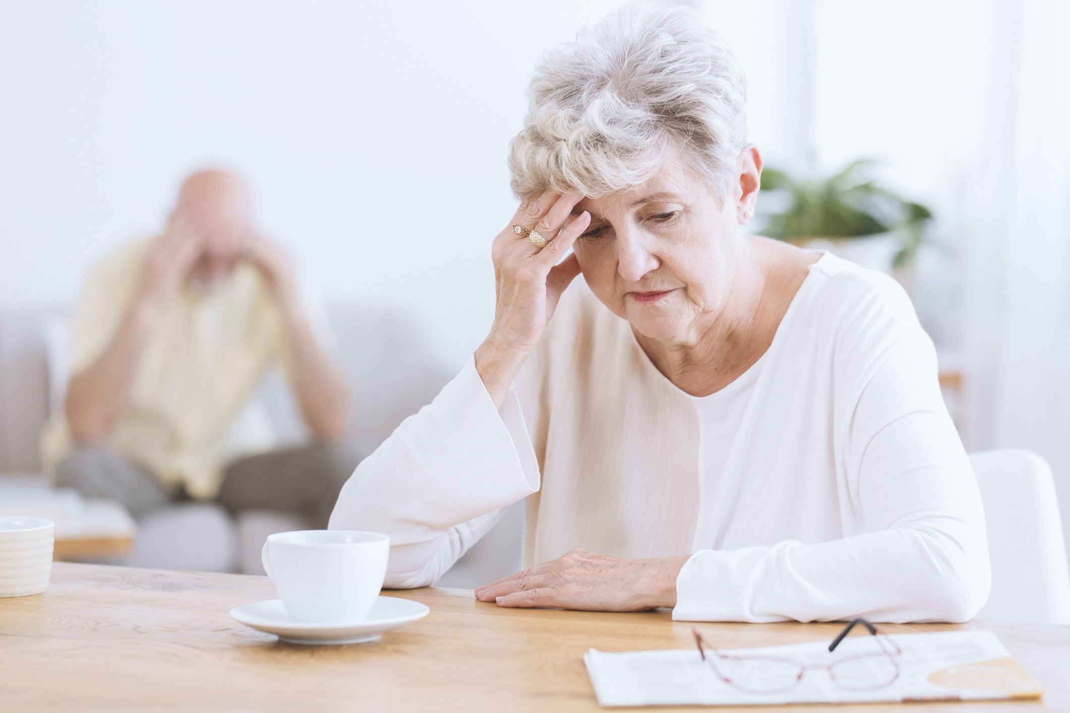 Sad senior woman sitting at desk.