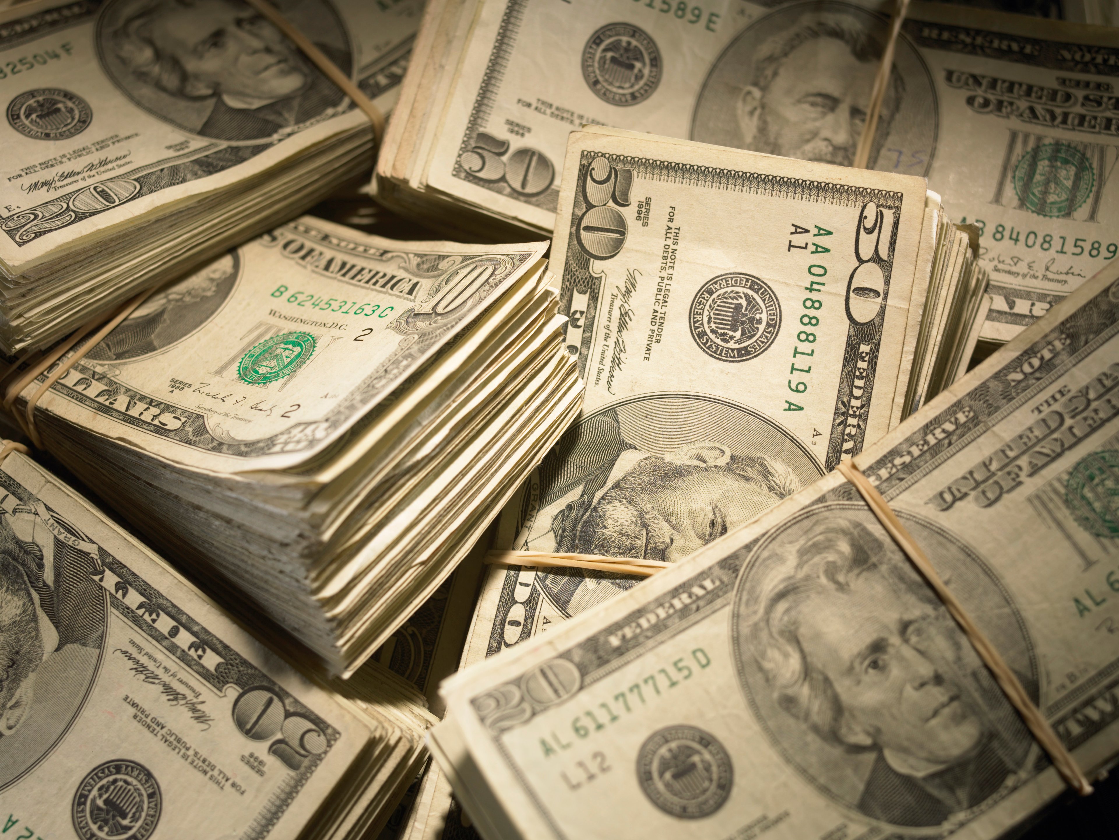 Piles of $10, $20, and $50 bills.