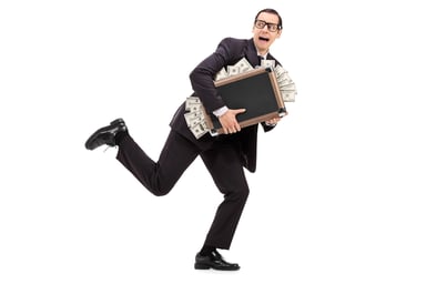 Businessman running with case stuffed with money
