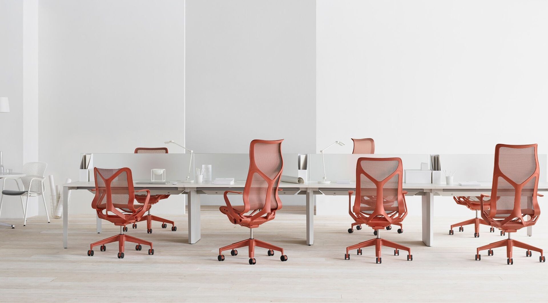 Red chairs surrounding a white desk.