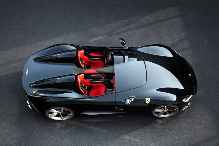 A black Ferrari Monza SP2, a sleek open-top sports car, viewed from above with its red seats visible.