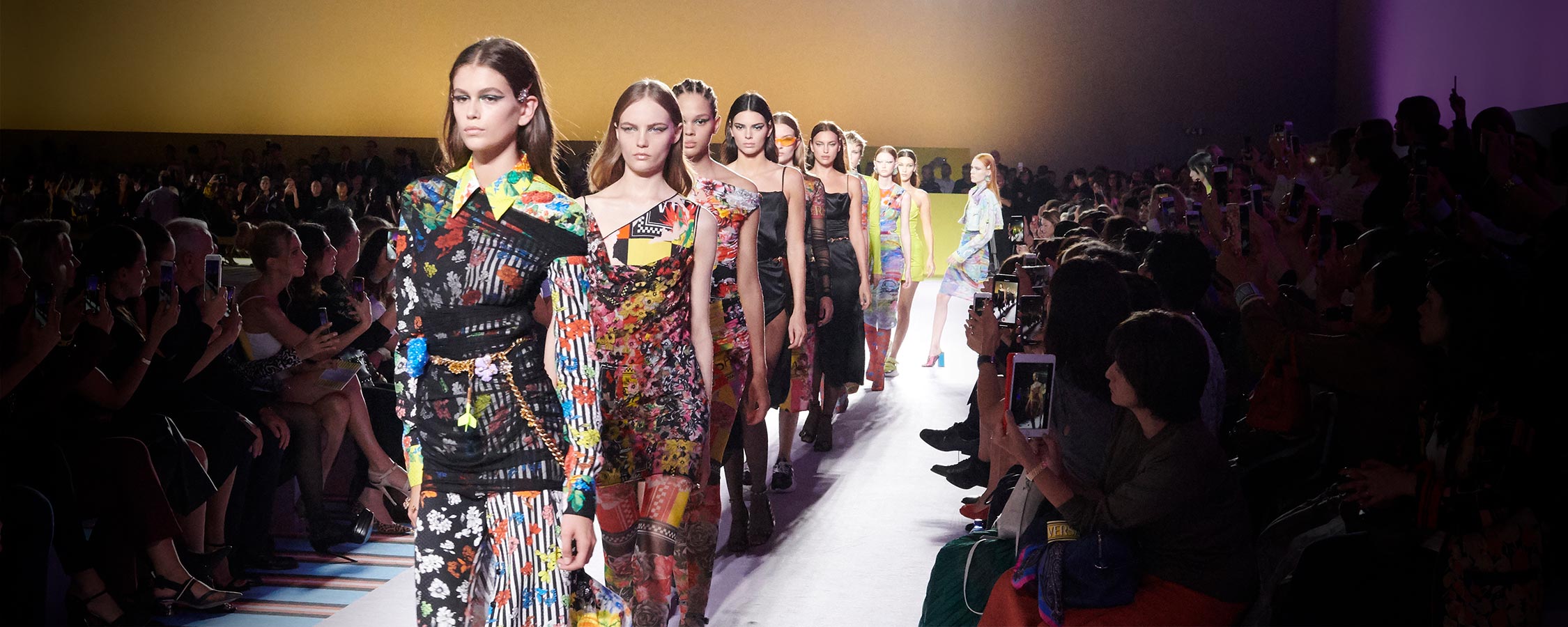 A line of models walking at a Versace runway show.