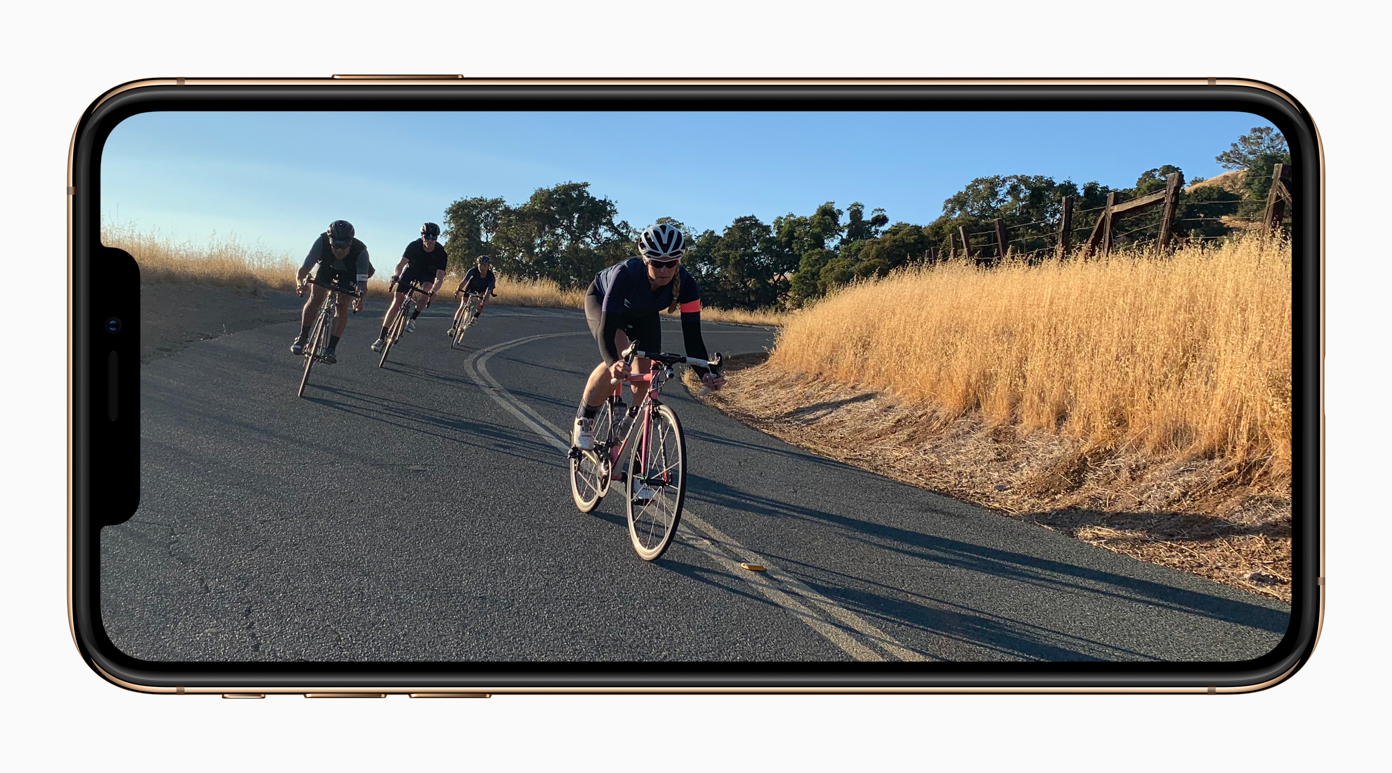 Apple's iPhone XS displaying people riding bikes on a road.