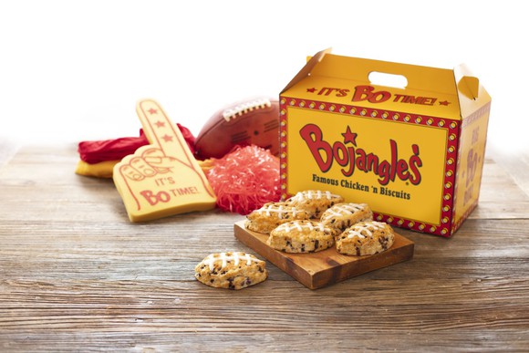 Box of Bojangles next to football-shaped biscuits, pompoms, a football, and a big-hand sign.