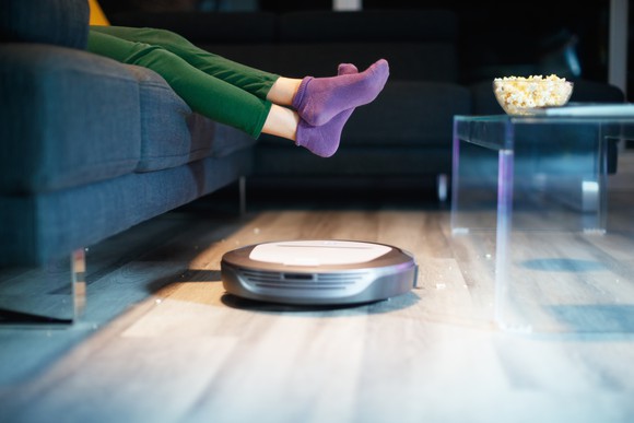 A robotic vacuum cleaner sweeps the floor.