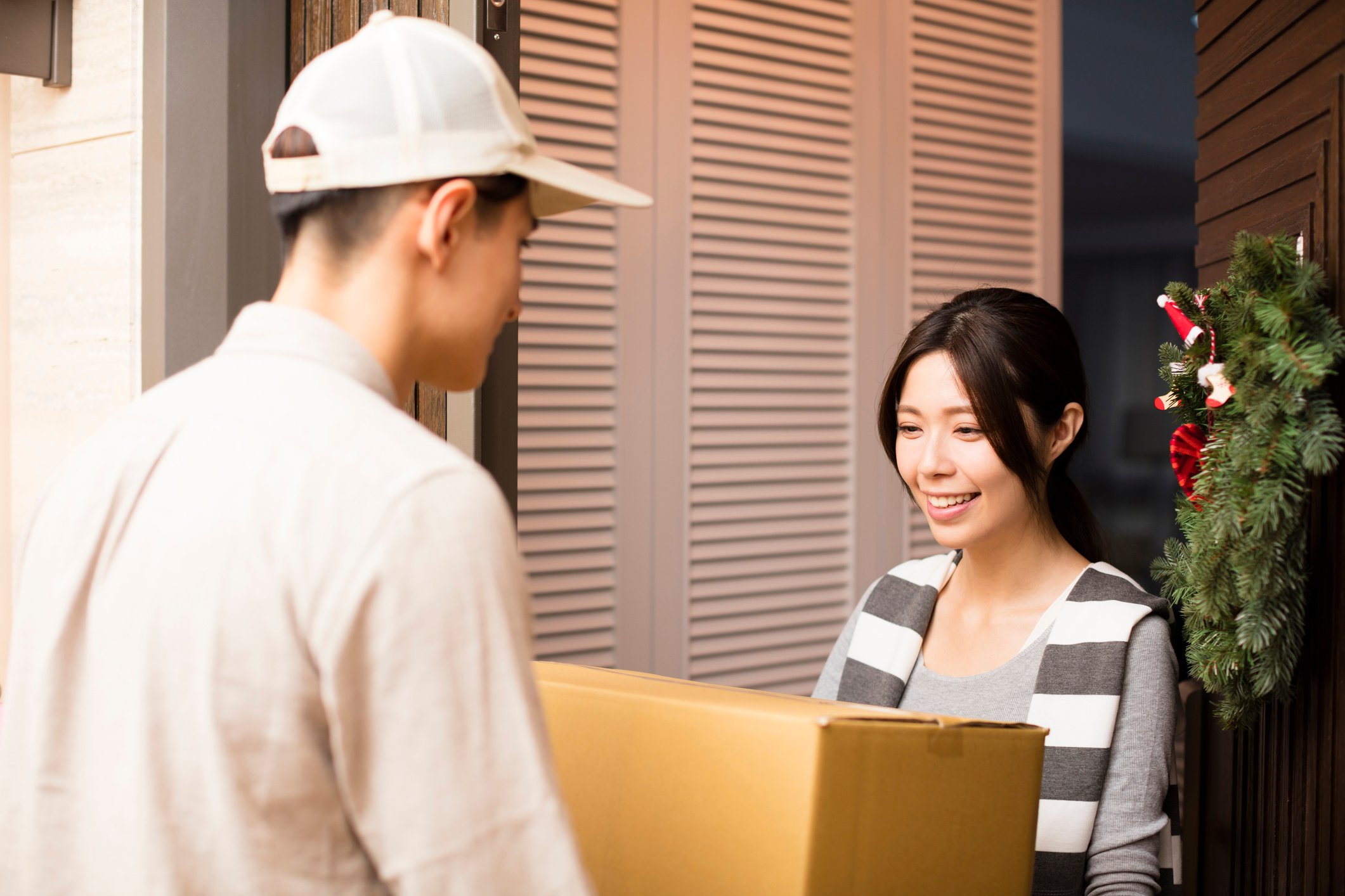 Young woman receiving package from delivery man