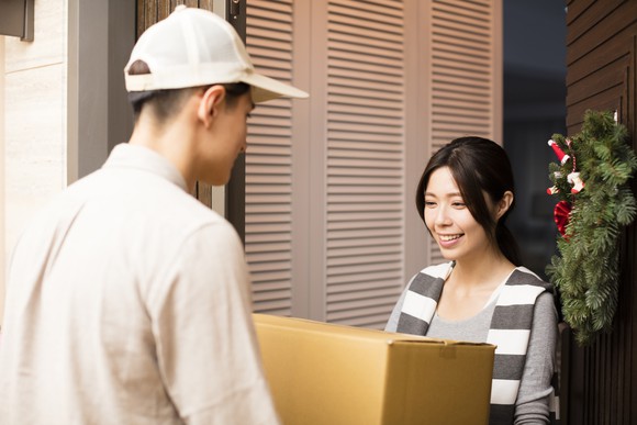 Young woman receiving package from delivery man