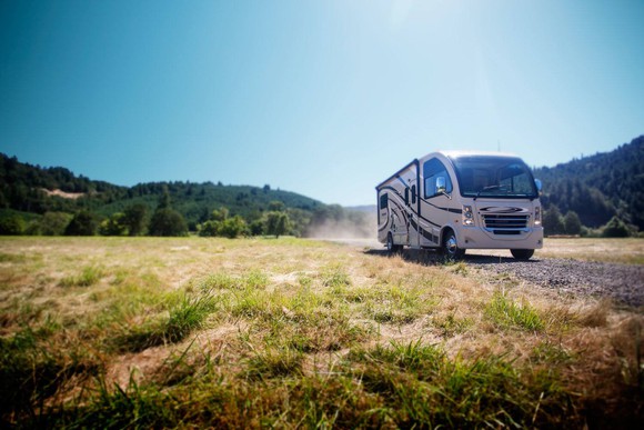 A Thor Industries RV driving on a road.