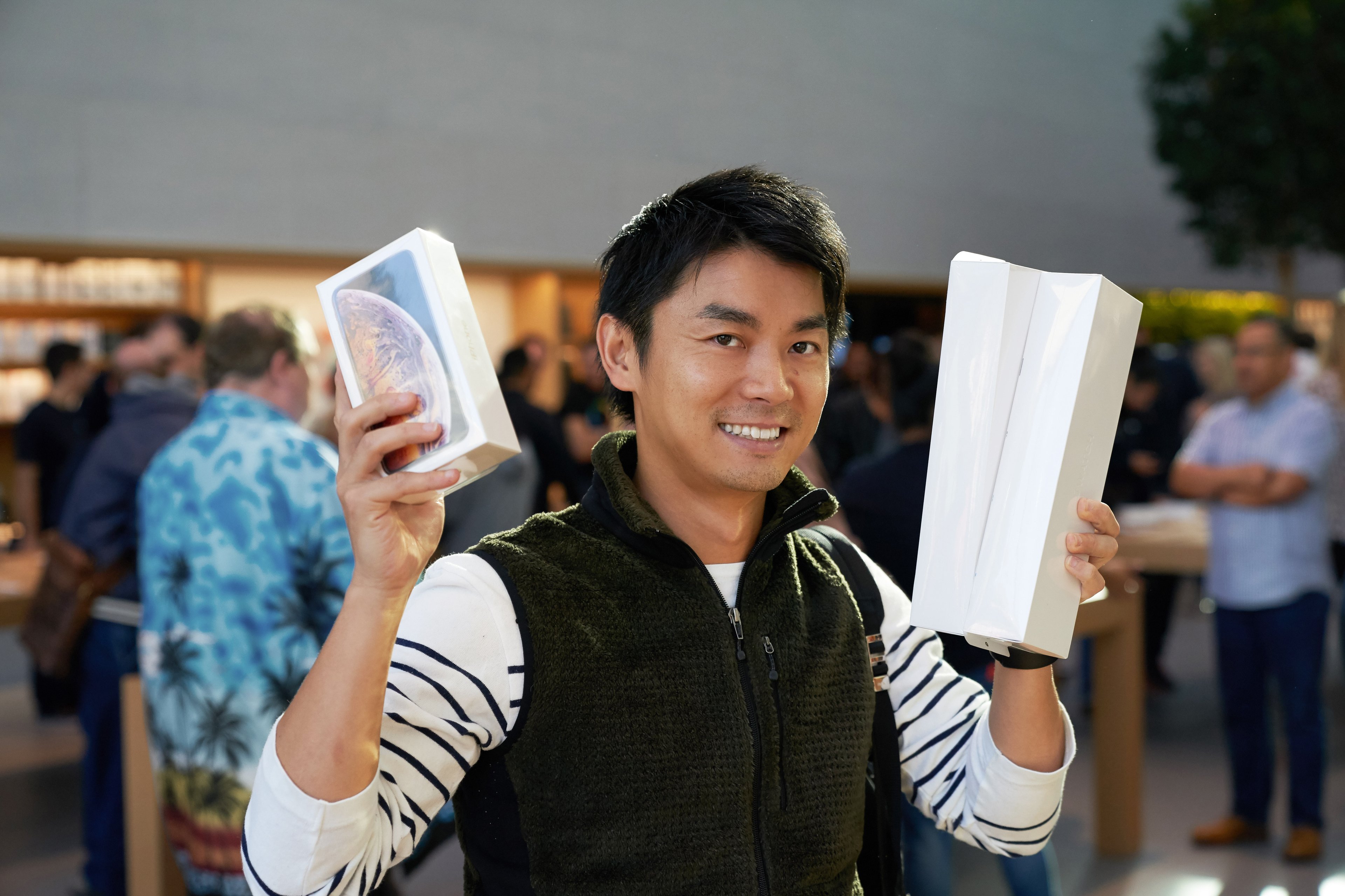 A man holding Apple products in an Apple store.