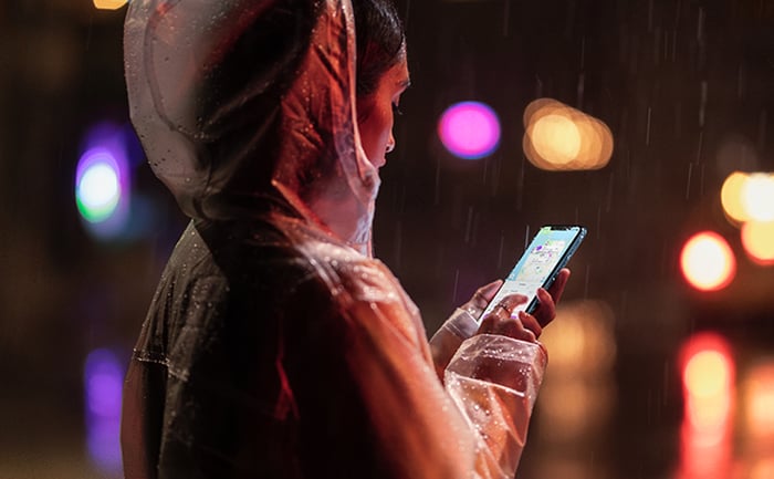 A person holding the iPhone XR in the rain.